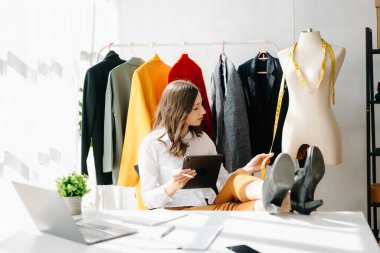 Beyaz kadın, moda tasarımcısı, tablet ve dizüstü bilgisayarı olan. 