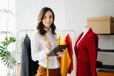 Kafkasyalı genç bir kadın, tabletli moda tasarımcısı.
