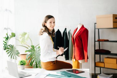 Beyaz kadın, moda tasarımcısı, tablet ve dizüstü bilgisayarı olan. 