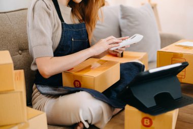  Ev ofisinde kutulu tablet kullanan kadın. 