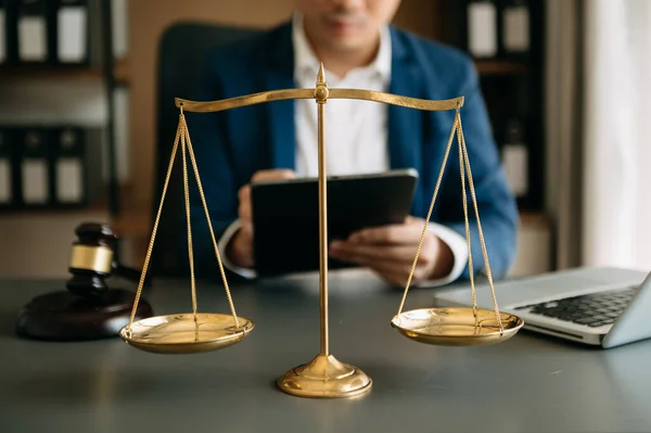 Male lawyer in the office with brass scale on wooden table. justice and law concept