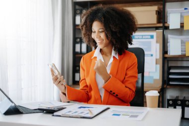 Afrikalı iş kadını, merkez ofisteki tablet bilgisayar ve telefondan memnun ve memnun.