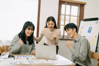  UX geliştiricisi ve ui tasarımcısı modern ofiste müşteri özeti ve renk kodu ile mobil uygulama arayüzü kablo tasarımı hakkında beyin fırtınası yapıyorlar