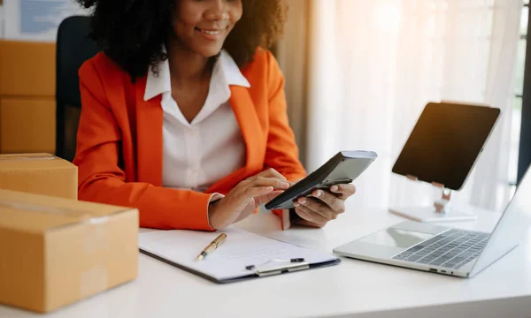 stock image african woman SME working with boxes at home the workplace.start-up small business owner, small business entrepreneur SME and delivery concept.