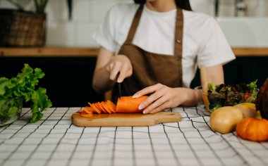 Açık mutfakta salata yaparken güzel bir yetişkin kadın. Evde sağlıklı yiyecek kavramı