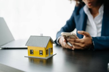 Emlak komisyoncusu, emlak kredisi teklifiyle ilgili karar veren imza anlaşmasını, ev modelini sunar ve müşteriye danışmanlık yapar.