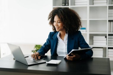 Afrikalı Kadın Serbest Çalışan, hesap makinesi ve dizüstü bilgisayar üzerinde çalışıyor. Muhasebe analizi, emlak yatırım verileri, modern ofis finansmanı