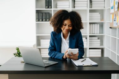 Afrikalı Kadın Serbest Çalışan, hesap makinesi ve dizüstü bilgisayar üzerinde çalışıyor. Muhasebe analizi, emlak yatırım verileri, modern ofis finansmanı