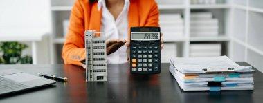 Emlak komisyoncusu, emlak kredisi teklifiyle ilgili karar veren imza anlaşmasını, ev modelini sunar ve müşteriye danışmanlık yapar.