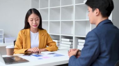 Ofiste konuşan ve dizüstü bilgisayar kullanan iki iş adamı..