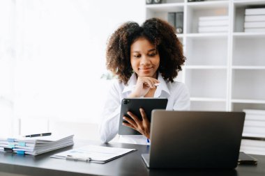 Bir ofis masası, vergi, rapor, muhasebe, istatistik ve analitik araştırma konseptinde matematik finansmanı için tablet ve dizüstü bilgisayar kullanan iş kadını