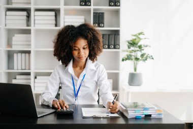 Bir ofis masasında matematik finansmanı, vergi, rapor, muhasebe, istatistik ve analitik araştırma kavramını kullanan iş kadını