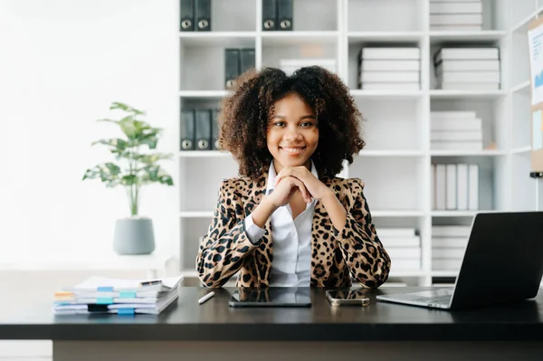 stock image Young African woman using laptop and tablet  at her working place. Concentrated at work