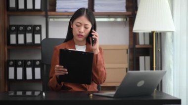 İş kadını telefonda konuşuyor ve bilgisayarını ofis masasında matematik finansmanı, vergi, rapor, muhasebe, istatistik ve analitik araştırma kavramında kullanıyor.
