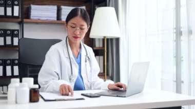 Hastanede ya da klinikte laptopla hastaya tıbbi tedaviyi anlatırken çekici kadın doktor konuşuyor..