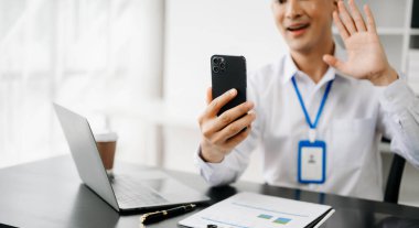 Sabah ışığında akıllı telefon ve dizüstü bilgisayar kullanan iş adamı.