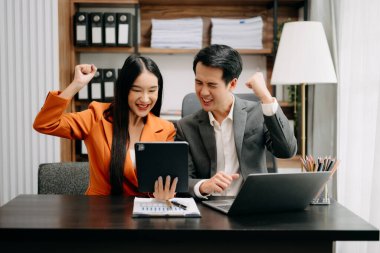 Genç Asyalı iş adamları yaratıcı iş adamları, takım çalışması başarıyı kutluyor ve modern ofisin yaratıcı tasarımını planlıyor.