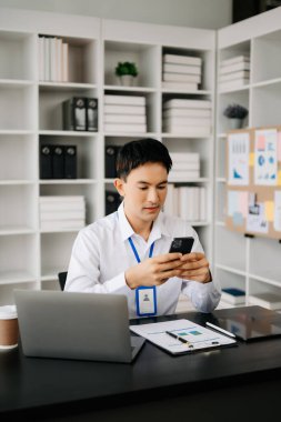 Genç Asyalı işadamı modern ofiste belgelerle çalışıyor. Vergi, rapor, muhasebe, istatistik ve analitik araştırma kavramı