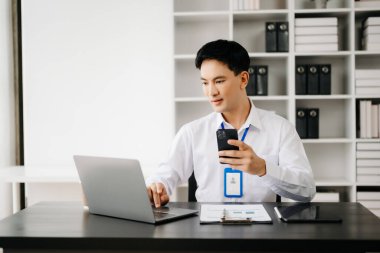 Genç Asyalı işadamı modern ofiste belgelerle çalışıyor. Vergi, rapor, muhasebe, istatistik ve analitik araştırma kavramı