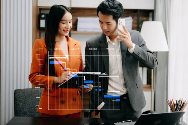 Gantt çizelgesi kullanarak sanal diyagram çizen iş adamları. Modern ofiste dizüstü bilgisayarla çalışan meslektaşlar