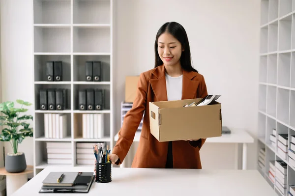 stock image Happy and excited young beautiful Asian woman office worker celebrating her resignation, carrying her personal stuff. leaving job, changing or company.in nodern offic