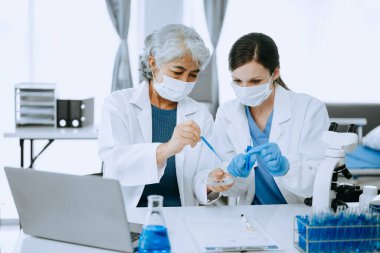Modern tıbbi araştırma laboratuvarı. Kadın bilim adamı mikro pipetlerle çalışıyor biyokimyasal örnekleri analiz ediyor, ileri bilim kimya laboratuvarı