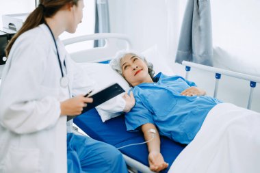  Kafkasyalı doktor gülümsüyor. Hastanedeki ya da klinikteki yaşlı bir hastayla ilgileniyor. Dost canlısı hemşire ya da tedavi edici müşteri Profesyonel Tıp Hizmetleri konsepti