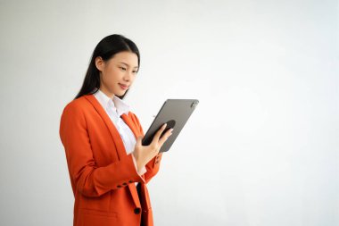 Beyaz arka planda, mutlu hisseden ve dijital tablet tutan güzel Asyalı kadının portre fotoğrafı reklam veya ürün için kullanılabilir, sunum konsepti