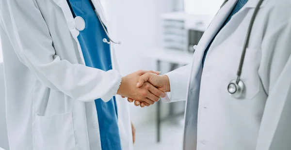 Doctor handshake and partnership in healthcare, medicine or trust for collaboration, unity or support.Team of medical experts shaking hands in teamwork for or success in clinic or hospital