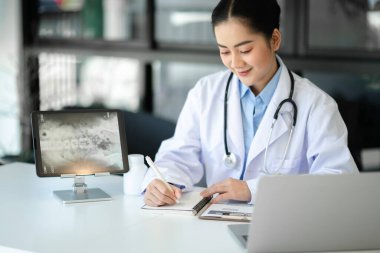 Tıbbi teknoloji konsepti. Ofisteki cep telefonu ve steteskopla çalışan bir doktor.