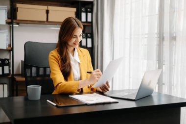 Kendine güvenen iş uzmanı çekici gülümseyen Asyalı kadın yaratıcı ofiste dijital tablet tutuyor..