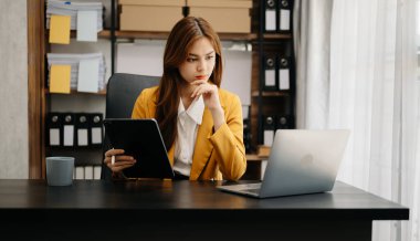 Kendine güvenen iş uzmanı çekici gülümseyen Asyalı kadın yaratıcı ofiste dijital tablet tutuyor..