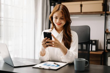 Kendine güvenen iş uzmanı çekici gülümseyen Asyalı kadın yaratıcı ofiste dijital tablet tutuyor..