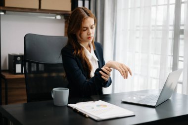 Ofis masasında uzun bir gün geçirdikten sonra boynu ağrıyan Asyalı genç işkadını ofis çalışanı. ofis sendromu kavramı