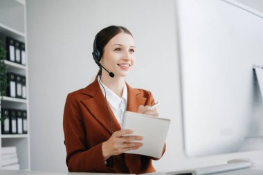 Telsiz kulaklıkla çağrı merkezi operatörü. Müşteriyle konuşuyor. Kulaklıklı, mikrofonlu bir kadın. 