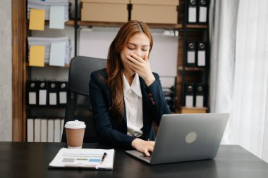 Ofis masasında uzun bir gün geçirdikten sonra boynu ağrıyan Asyalı genç işkadını ofis çalışanı. ofis sendromu kavramı