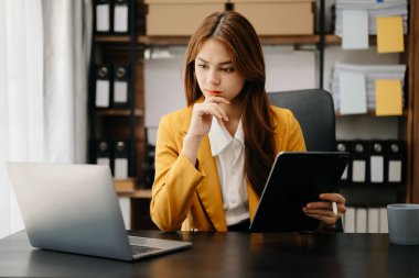 Kendine güvenen iş uzmanı çekici gülümseyen Asyalı kadın yaratıcı ofiste dijital tablet tutuyor..