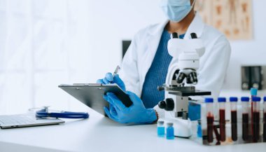 Afrikalı kadın biyoteknoloji uzmanı bir laboratuarda yeni kimyasal maddeler test ediyor..