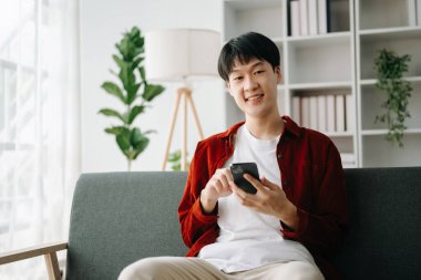 Genç ve çekici Asyalı adam evden çalışıyor.