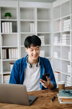 Genç ve çekici Asyalı adam evden çalışıyor.