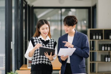 Ofiste birlikte çalışan iki mutlu Asyalı iş adamı.