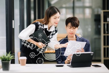 Asyalı iş ekibi burada. Profesyonel yatırımcı yeni bir başlangıç projesi üzerinde çalışıyor. Sanal simge tasarım yöneticileri toplantısında dijital pazarlama ortamına sahip tablet dizüstü bilgisayar