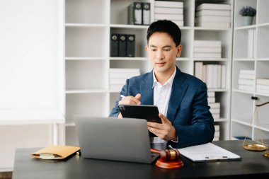 Ofisinde çalışan çekici bir avukat. Laptop, ahşap tokmak, pirinç pulu ve belgeler modern ofiste masanın üzerinde. Hukuk, hukuk hizmetleri kavramı