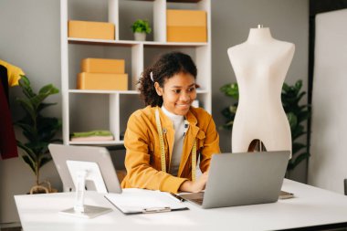 Genç Afrikalı kadın moda tasarımcısı. Stüdyoda mutlu bayan terzi