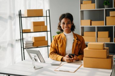 Küçük işletme girişimcisi KOBİ serbest çalışan Afrikalı kadın ev ofisi, BOXes, tablet ve İnternet, pazarlama, paketleme, dağıtım, e-ticaret konsepti