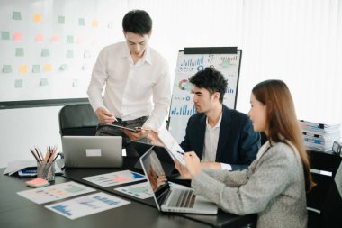 Asyalı iş adamlarından oluşan bir grup modern ofiste projenin tasarımı ve tasarımı ile buluşuyor.