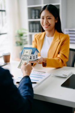 Satıcı Eller, Müşteri Evi Modeli, Küçük Oyuncak Evi Küçük İpotek Emlak Sigortası ve Gayrimenkul kavramlarını gösteriyor