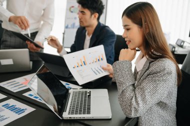 Bir grup Asyalı iş adamı modern yaratıcı ofiste iş planlarını tartışıyor.