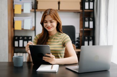 Ana ofiste tablet kullanan Asyalı bir iş kadını.