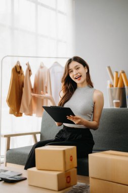 Moda blogcusu konsepti, internette kıyafet satan genç Asyalı kadın. Başlangıçta küçük işletme KME